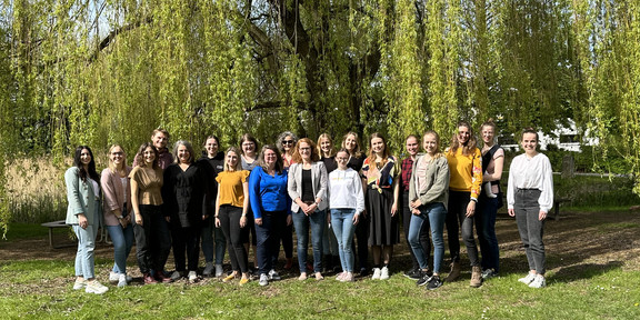 Außenaufnahme Gruppenbild des S&K-Teams bei sonnigem Wetter vor einer Weide