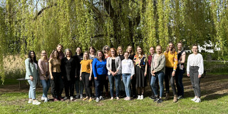 Gesamtes SuK Team Außenaufnahme Gruppenbild des S&K-Teams bei sonnigem Wetter vor einer Weide